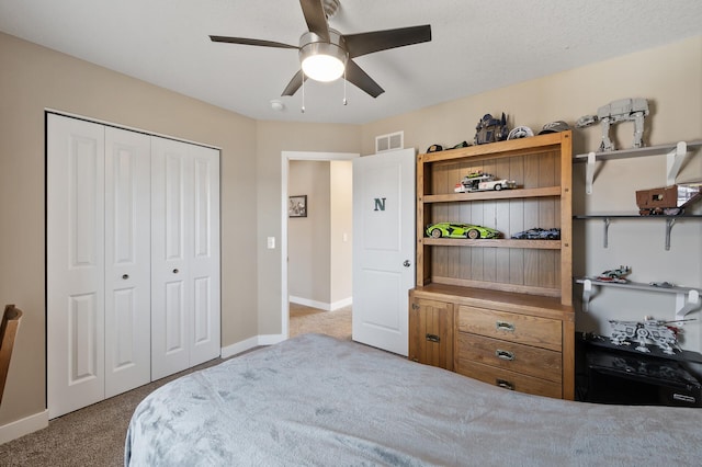 bedroom with visible vents, baseboards, ceiling fan, carpet flooring, and a closet