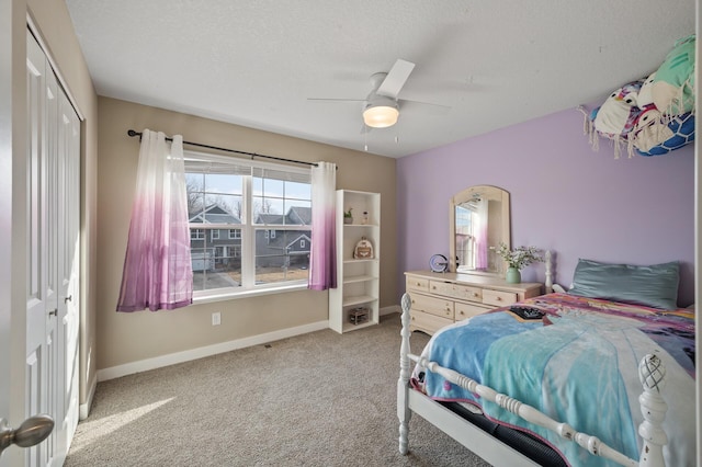 bedroom with baseboards, light carpet, a textured ceiling, and a closet