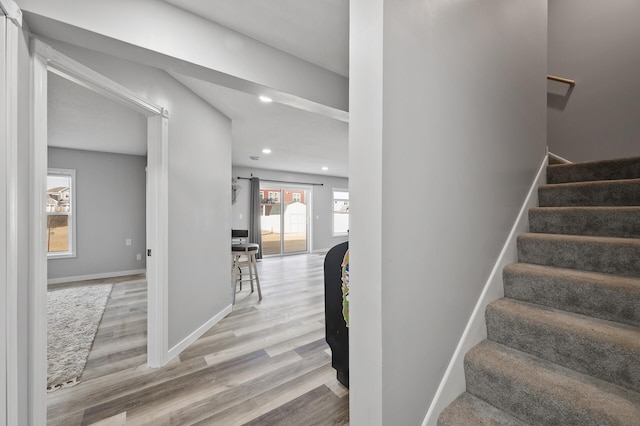 stairway featuring recessed lighting, baseboards, and wood finished floors