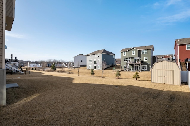 view of yard featuring an outbuilding, a shed, and a residential view