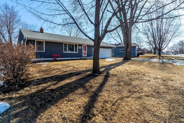 single story home with a chimney and an attached garage