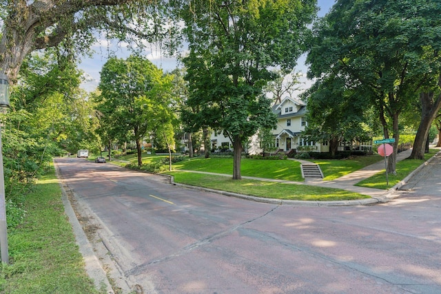 view of road featuring traffic signs, curbs, and sidewalks