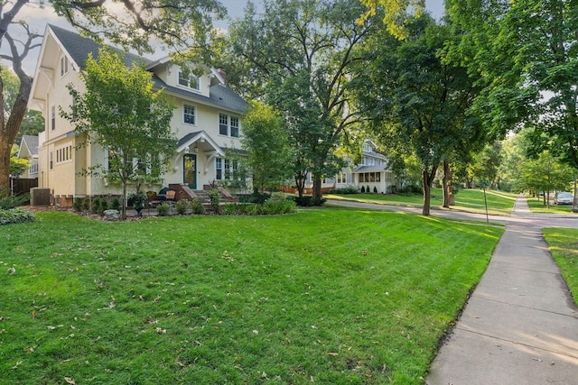 exterior space featuring a front yard, central air condition unit, and stucco siding