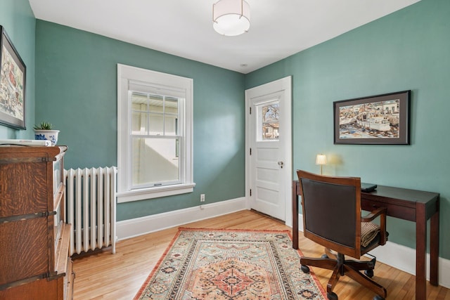 home office with baseboards, radiator, and wood finished floors