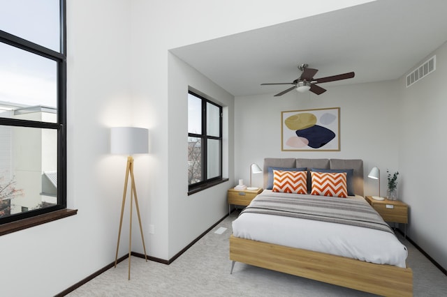 carpeted bedroom featuring a ceiling fan, visible vents, and baseboards