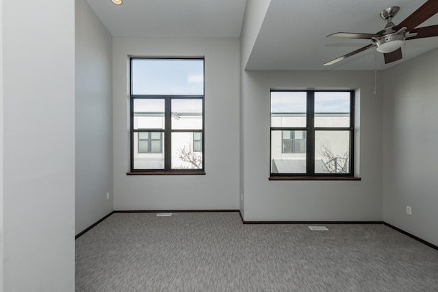 unfurnished room featuring visible vents, carpet floors, a ceiling fan, and baseboards