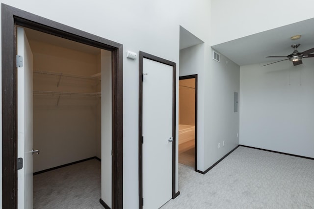 unfurnished bedroom with light carpet, visible vents, baseboards, a spacious closet, and a closet