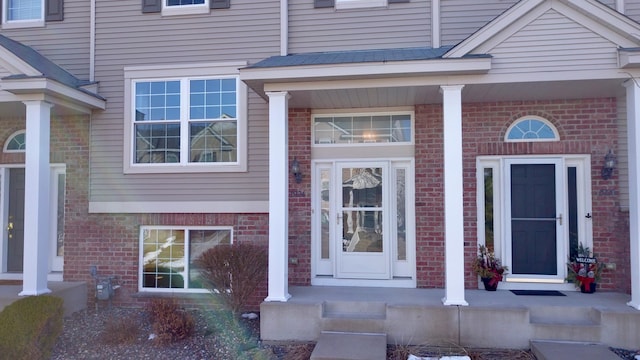 entrance to property featuring brick siding