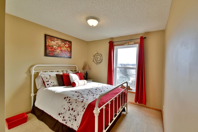 bedroom with baseboards, carpet floors, and a textured ceiling