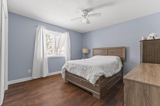 bedroom with dark wood finished floors, a textured ceiling, baseboards, and a ceiling fan