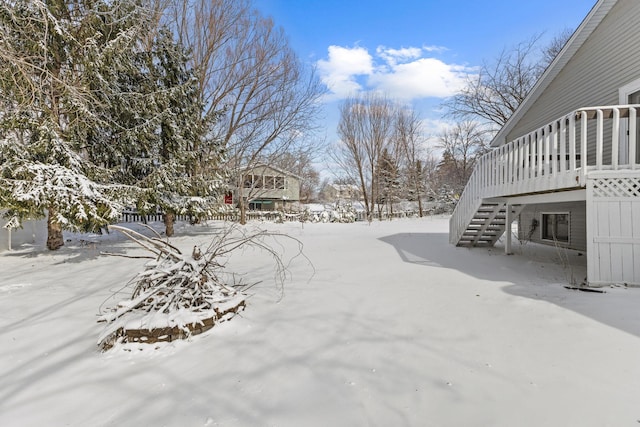 yard covered in snow with stairway and a deck