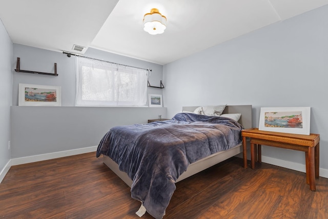 bedroom with visible vents, baseboards, and wood finished floors