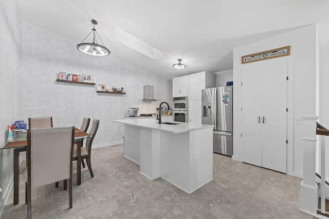 kitchen with a sink, white cabinetry, stainless steel appliances, a skylight, and light countertops