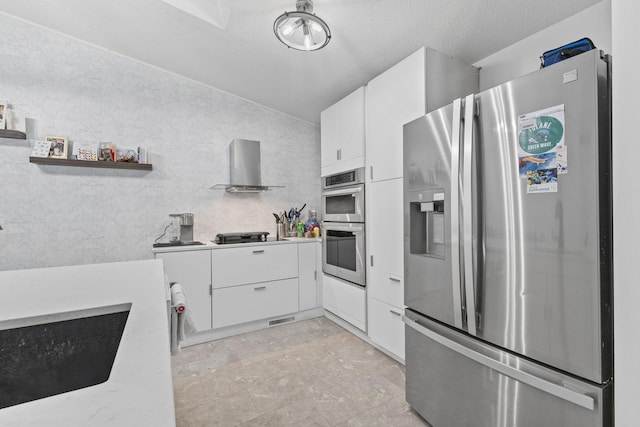 kitchen with open shelves, white cabinetry, appliances with stainless steel finishes, wall chimney exhaust hood, and light countertops