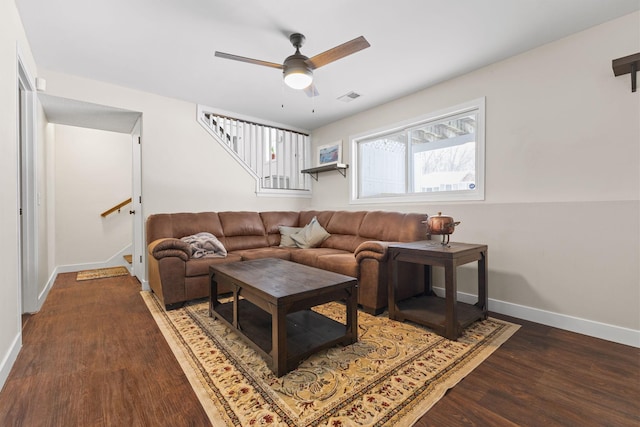 living area with stairway, wood finished floors, visible vents, baseboards, and ceiling fan