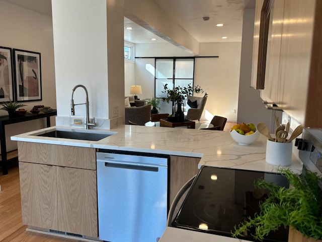 kitchen with dishwasher, modern cabinets, light stone counters, light wood-type flooring, and a sink