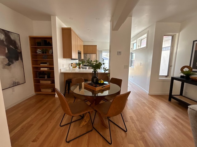 dining area with light wood-style floors and baseboards