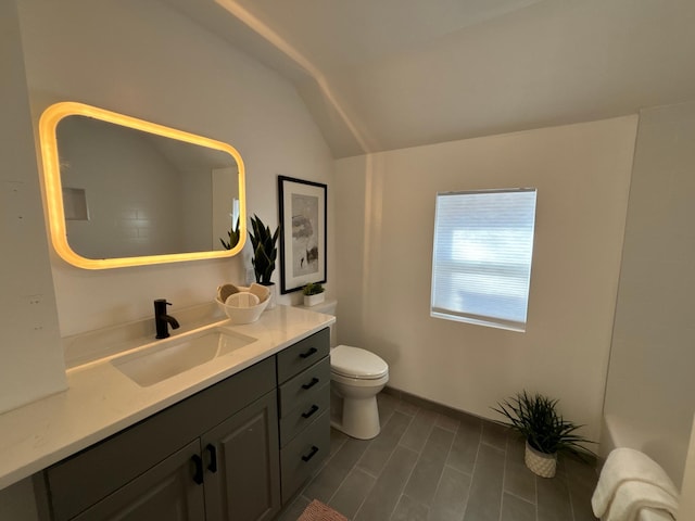 bathroom featuring vaulted ceiling, toilet, and vanity