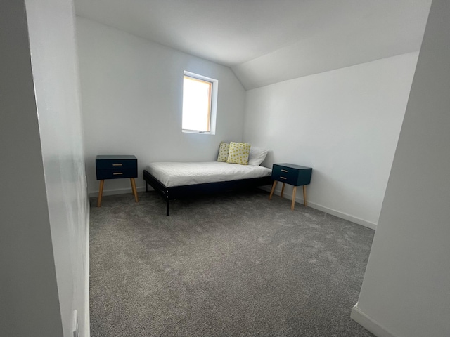 bedroom featuring vaulted ceiling, carpet floors, and baseboards