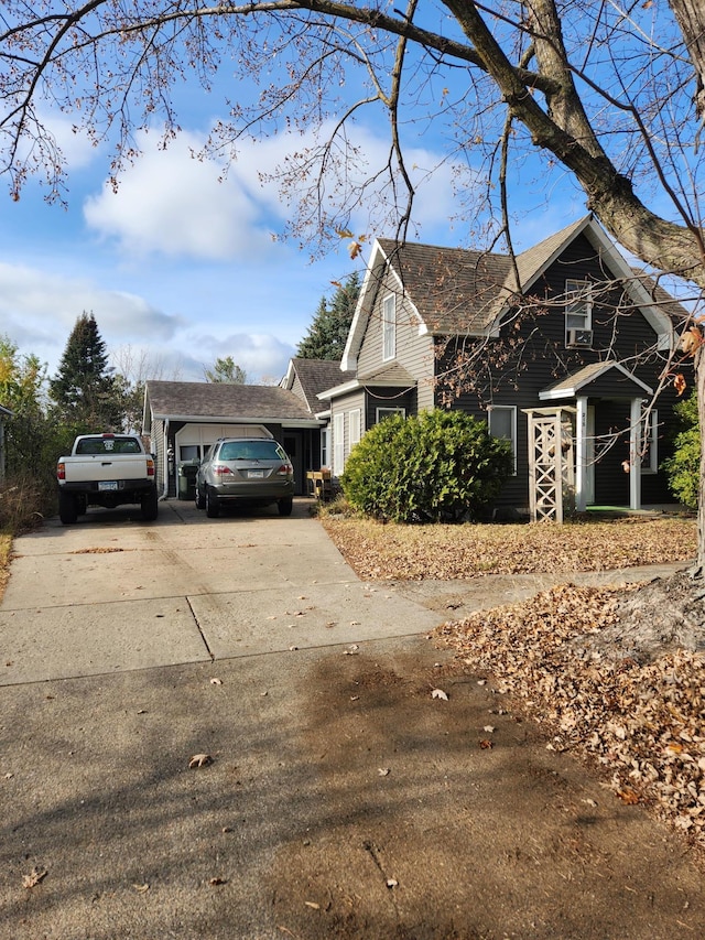 view of home's exterior featuring roof with shingles and concrete driveway