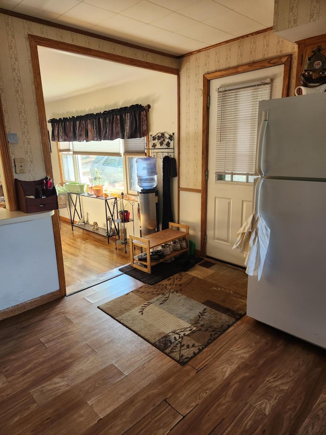 interior space with wood finished floors and wallpapered walls