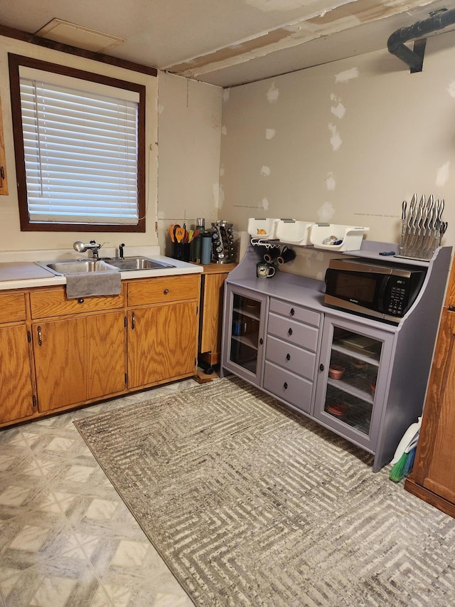 bar featuring stainless steel microwave, a sink, light floors, and wine cooler