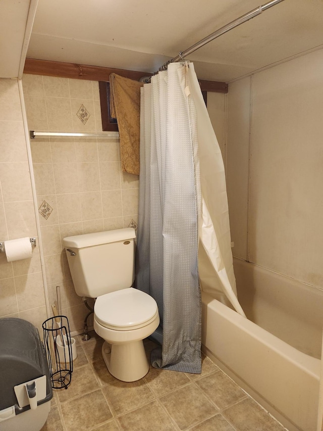 bathroom featuring toilet, shower / tub combo, and tile walls