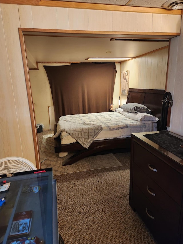 carpeted bedroom featuring wood walls