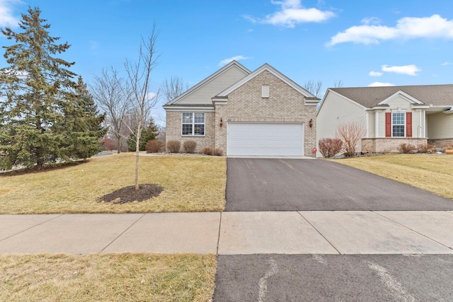 view of front of home with an attached garage, aphalt driveway, a front lawn, and brick siding