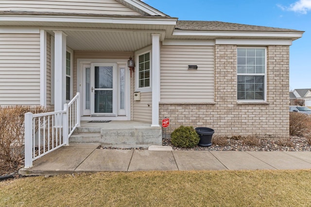 doorway to property featuring brick siding