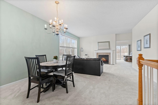 dining area featuring light carpet, a fireplace, a notable chandelier, and baseboards