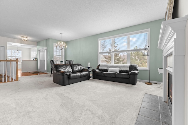 carpeted living room featuring a fireplace with flush hearth, a notable chandelier, plenty of natural light, and a textured ceiling