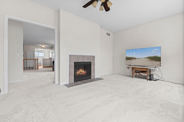 unfurnished living room with carpet, visible vents, baseboards, and a tile fireplace