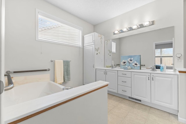 full bathroom with double vanity, visible vents, tile patterned flooring, a textured ceiling, and a sink