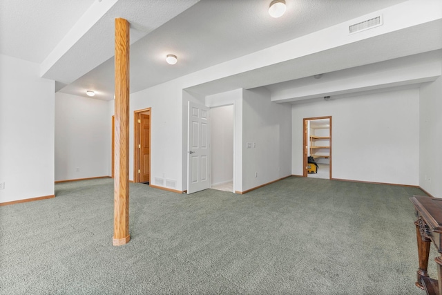 finished basement featuring carpet, visible vents, and baseboards