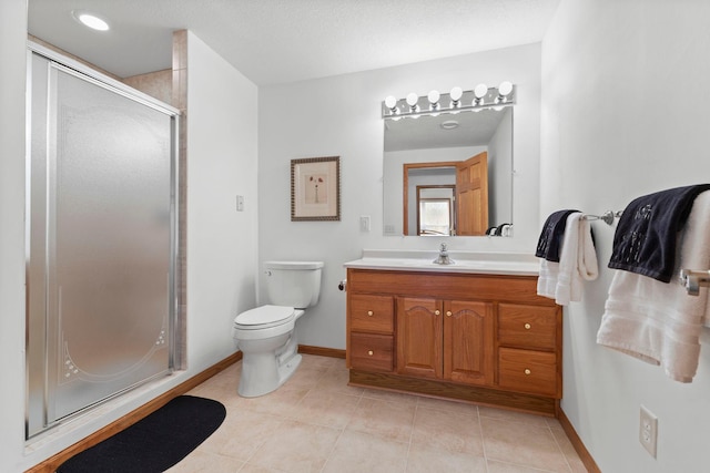 bathroom featuring baseboards, toilet, tile patterned floors, vanity, and a shower stall