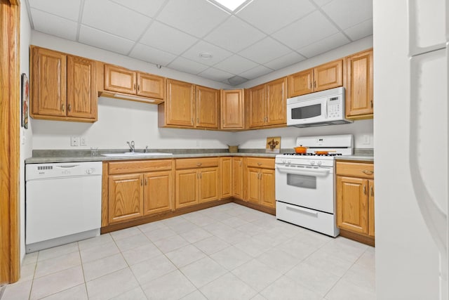 kitchen featuring white appliances, a sink, and a paneled ceiling