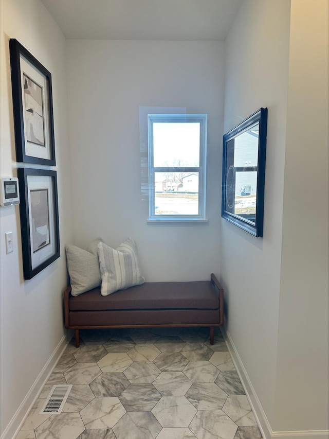 living area featuring marble finish floor, baseboards, and visible vents