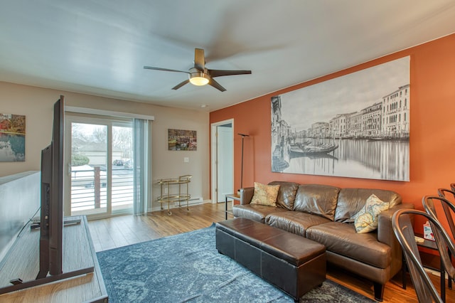 living area with a ceiling fan, baseboards, and wood finished floors