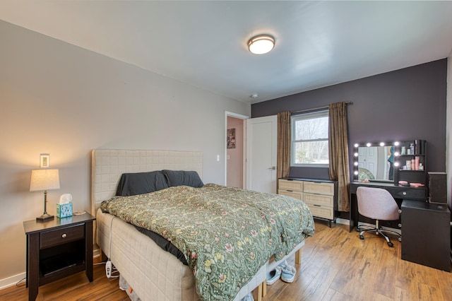 bedroom featuring baseboards and hardwood / wood-style flooring