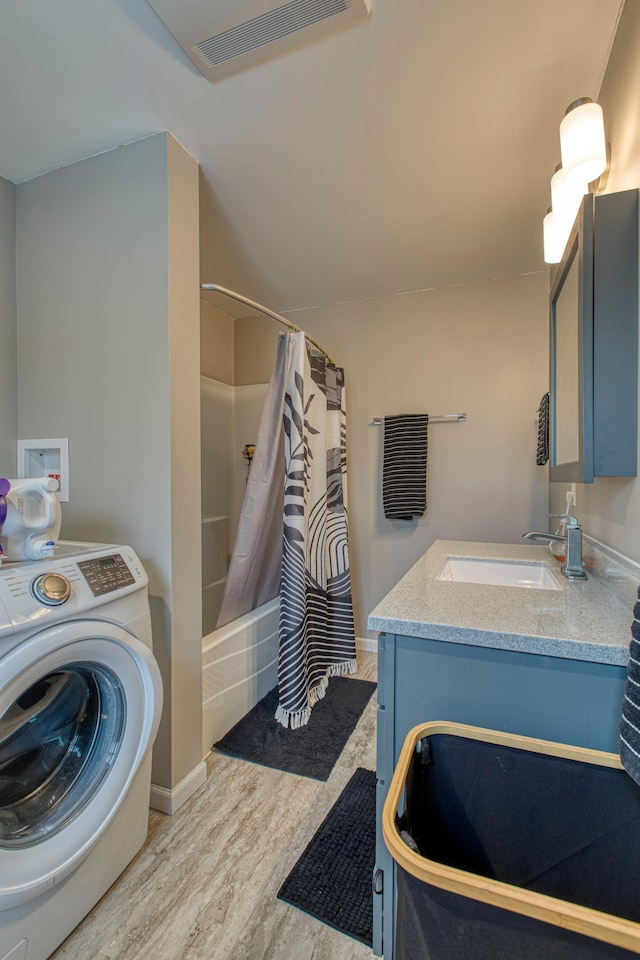 full bath with wood finished floors, visible vents, vanity, shower / bath combo, and washer / dryer