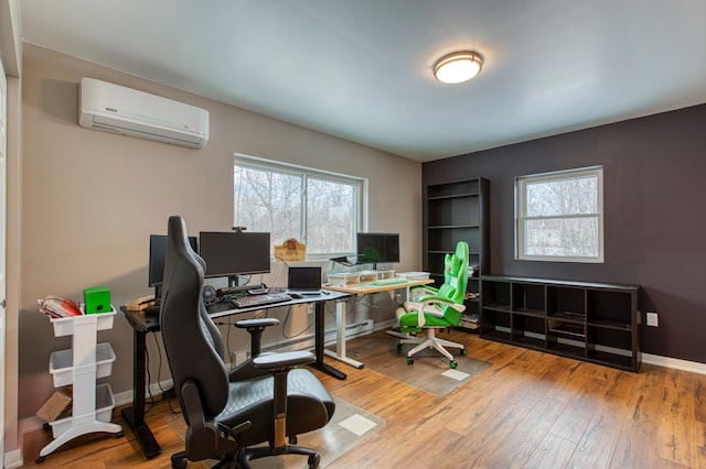 home office featuring an AC wall unit, plenty of natural light, and wood-type flooring