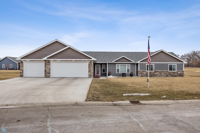 view of front of house featuring a front yard, an attached garage, concrete driveway, and stone siding