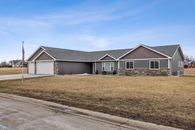 view of front of home with a front lawn, stone siding, concrete driveway, a shingled roof, and a garage