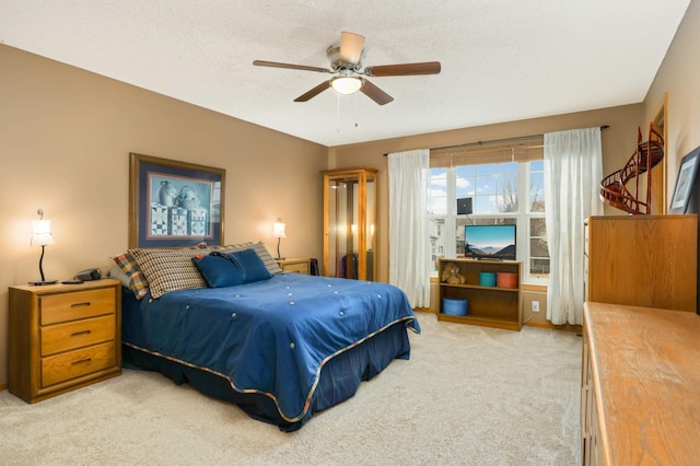 bedroom with carpet, ceiling fan, and a textured ceiling