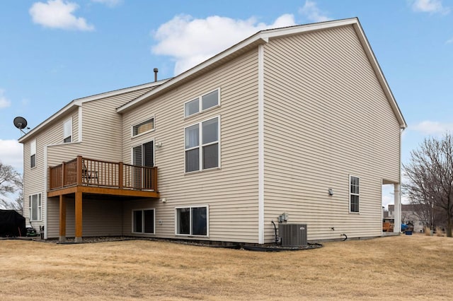 rear view of property featuring cooling unit, a lawn, and a deck