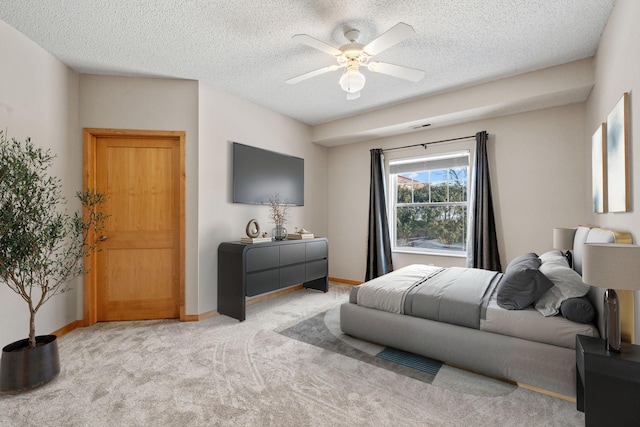 bedroom featuring a ceiling fan, carpet, baseboards, and a textured ceiling