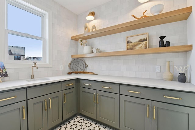 kitchen with light countertops, a sink, decorative backsplash, and open shelves