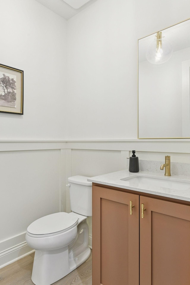 bathroom with vanity, toilet, and wood finished floors