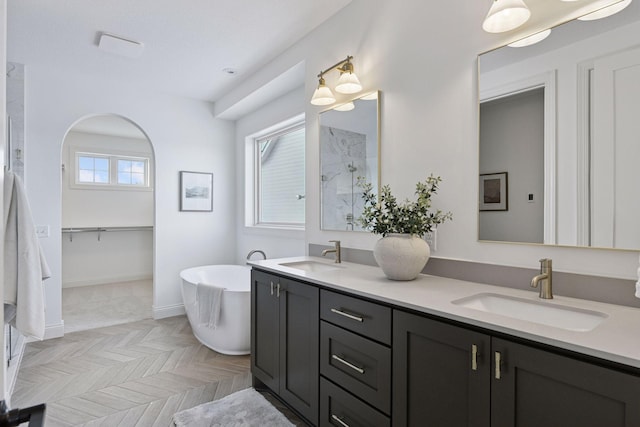 full bath featuring double vanity, a soaking tub, a shower, and a sink